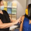 woman in black sleeveless shirt wearing white face mask