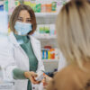 Pharmasict serving customer at drug store
